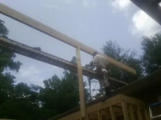 Carpenter setting a ridge beam over a new addition frame — Ice Dam Removal by Roofing Brothers in Charleston Afb