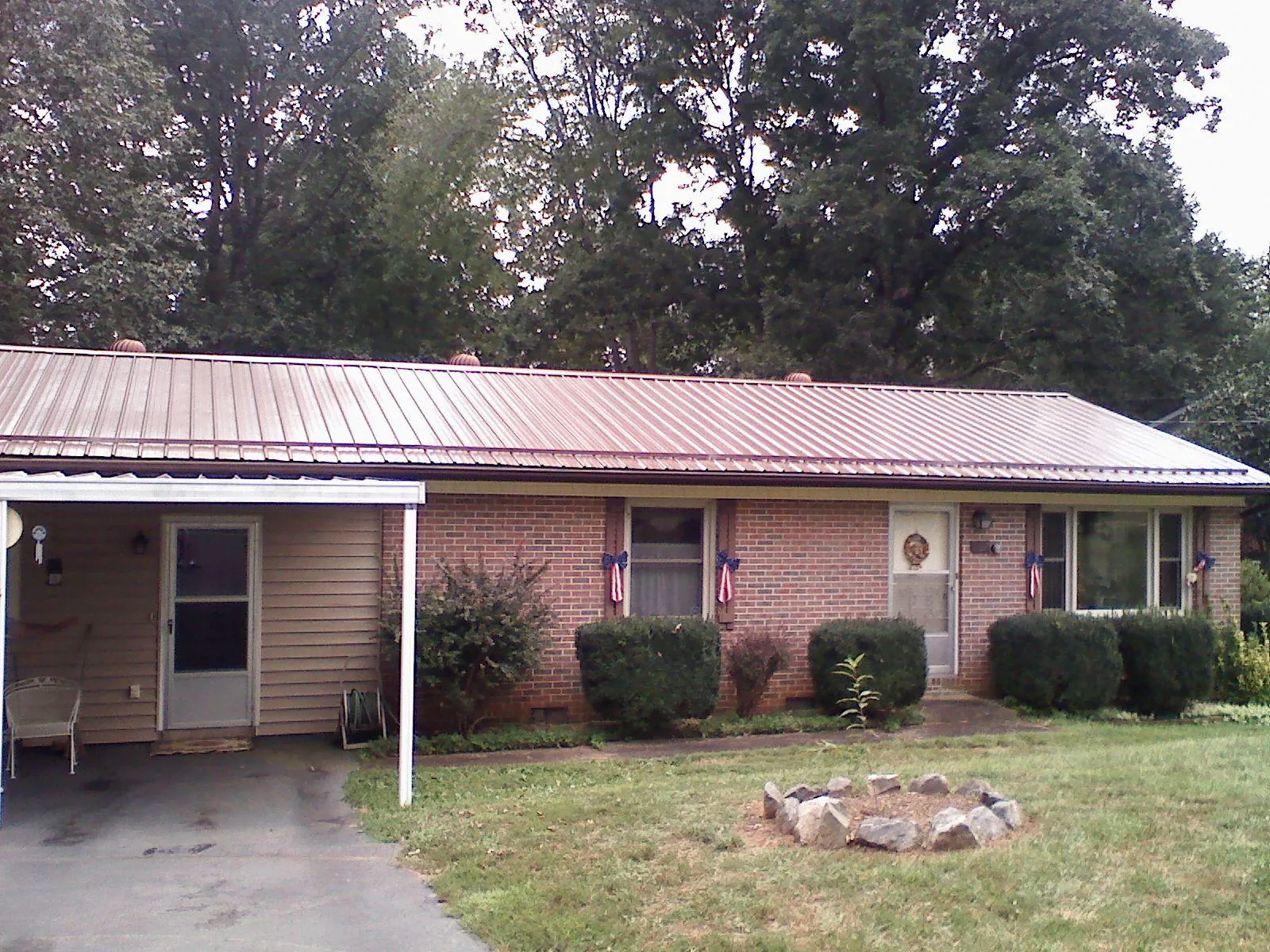 Bronze metal roof and carport on a brick ranch home — Roof Repair work by our crew in Charleston Afb